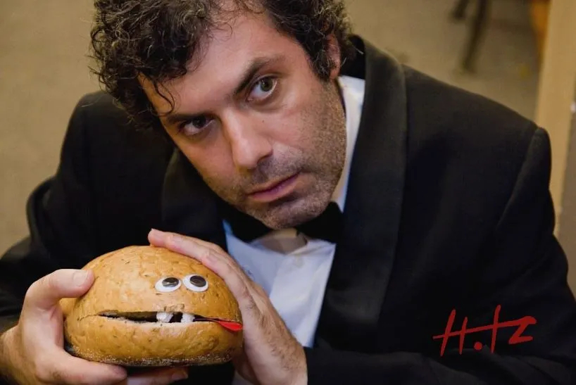 A poster of Kenny Hotz in a suit holding Ryan the rye bread with his Hotz signature on it